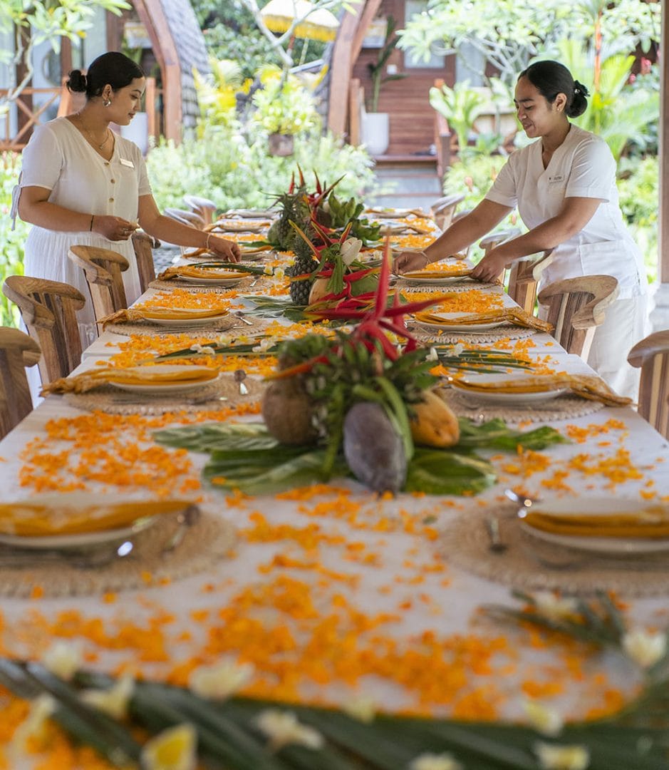ubud Villa women decorate dinner table for meal on bali goddess retreat