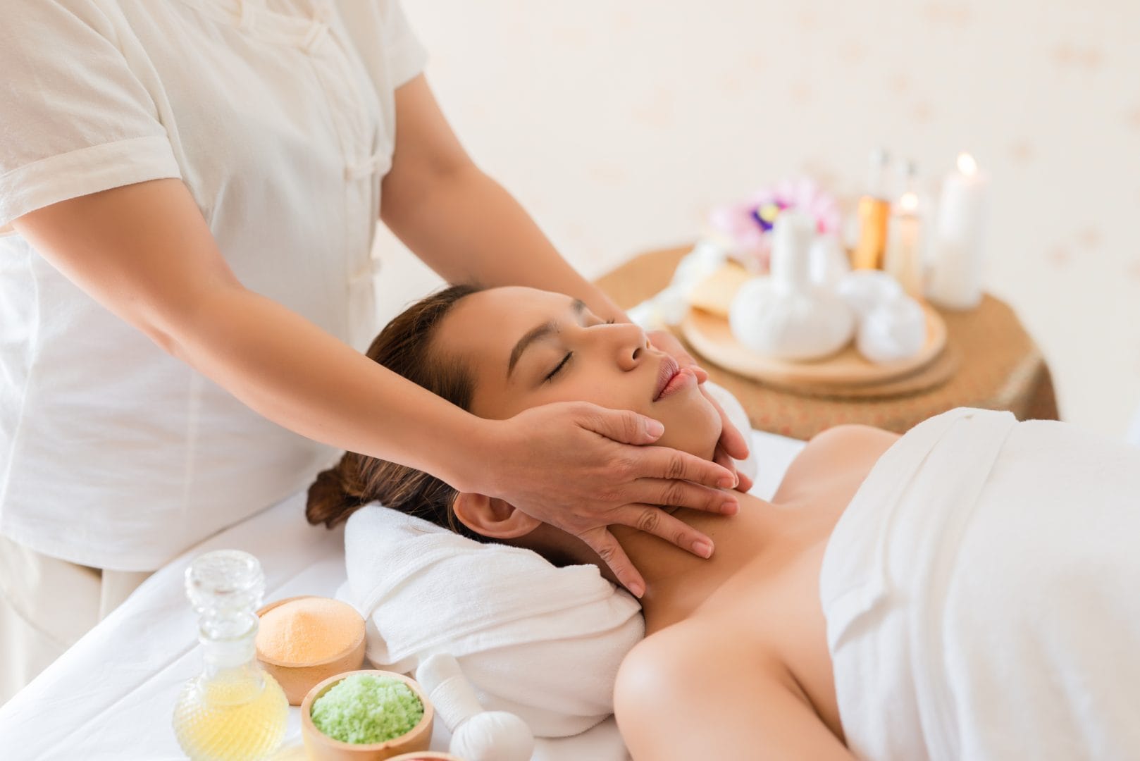 Woman receiving facial massage with products while lying on a spa bed at Bali wellness retreat