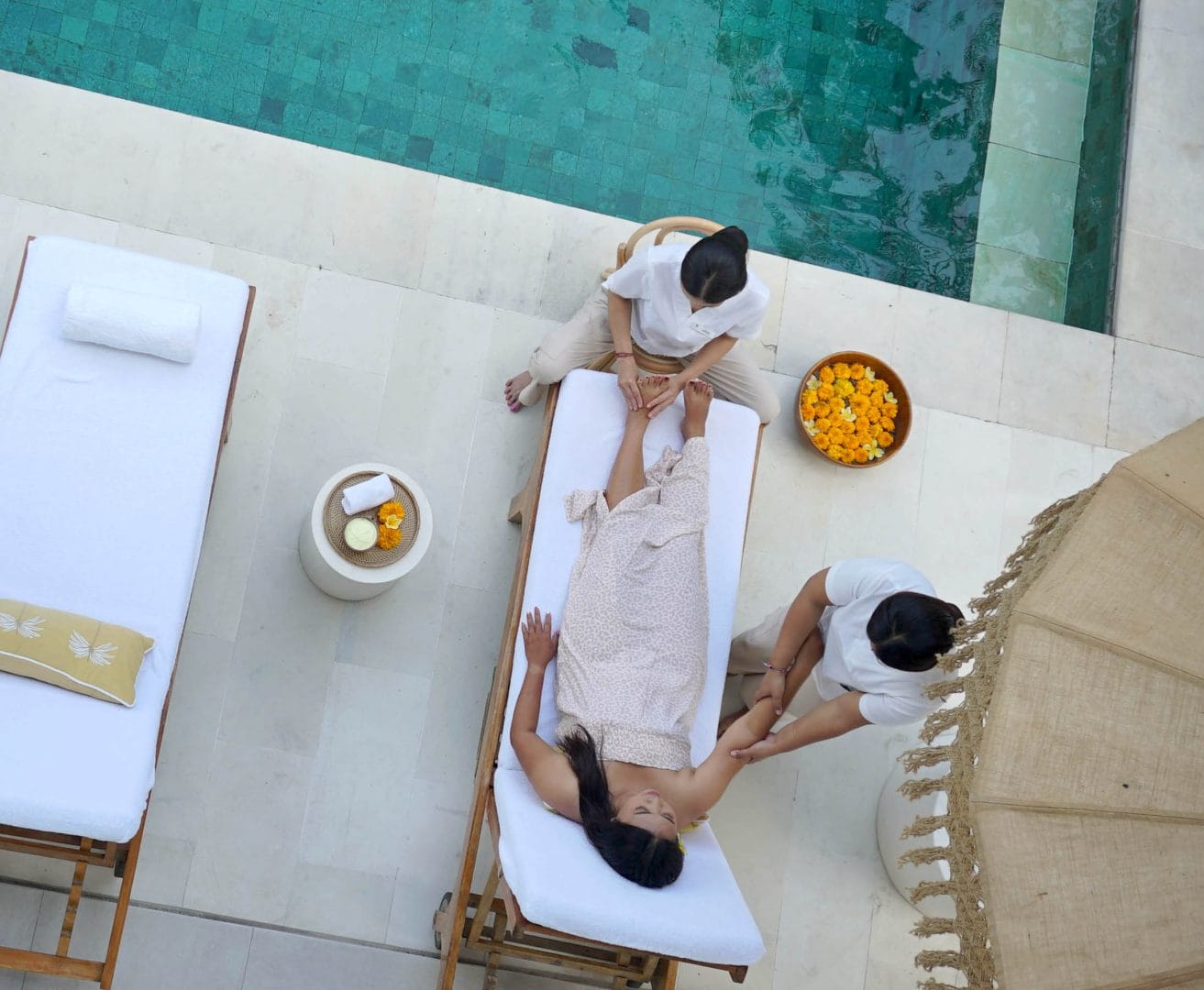 woman gettign a foot reflexology massage by seminyak pool at bali goddess retreats