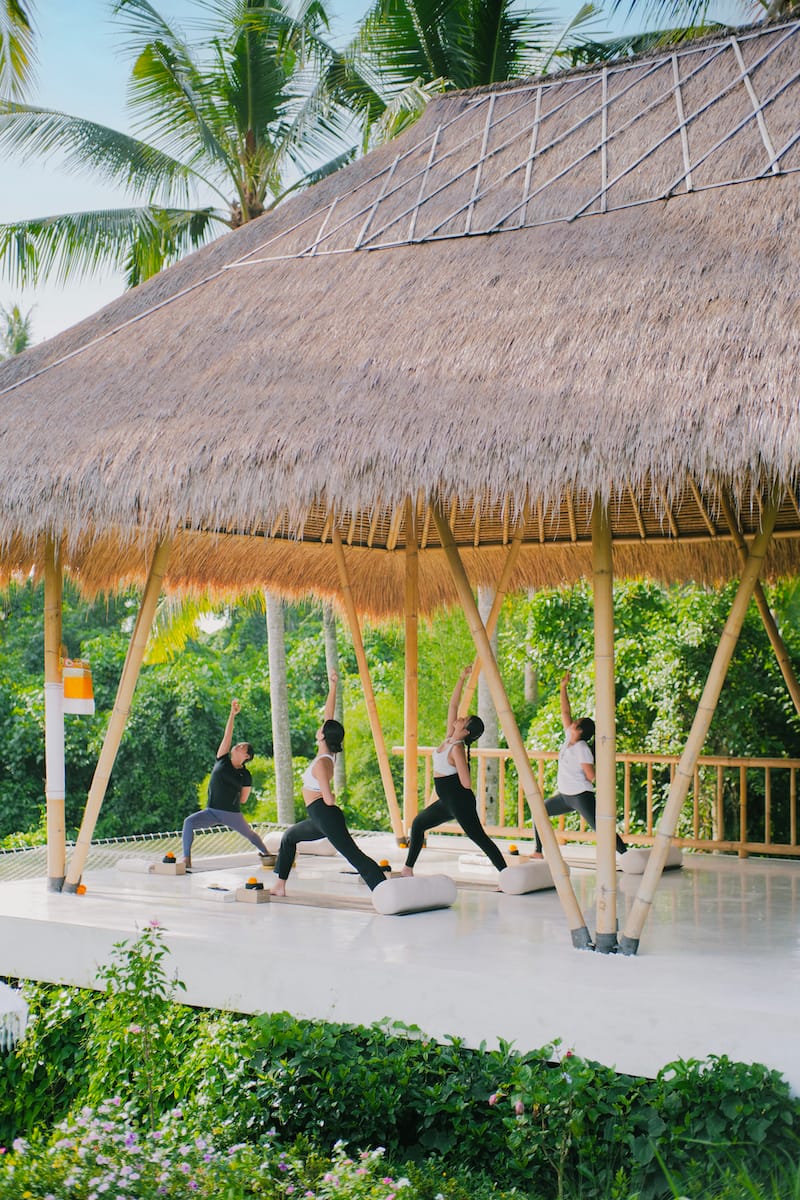 Spacious and serene yoga shala at Goddess Retreats, with wooden floors, large windows, and mats ready for a transformative yoga session